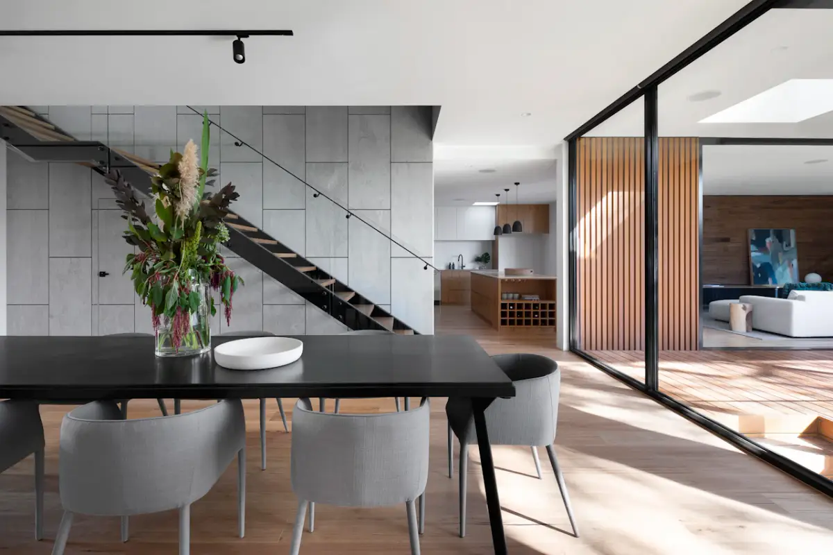 Comedor contemporáneo con cocina al fondo y patio de madera